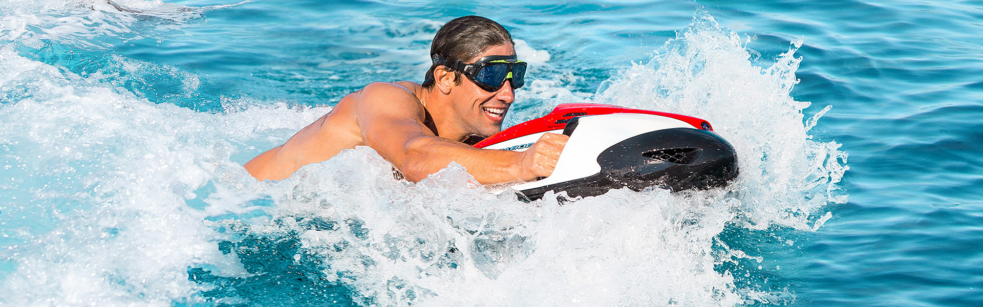 Guest riding a Seabob underwater scooter over turquoise water